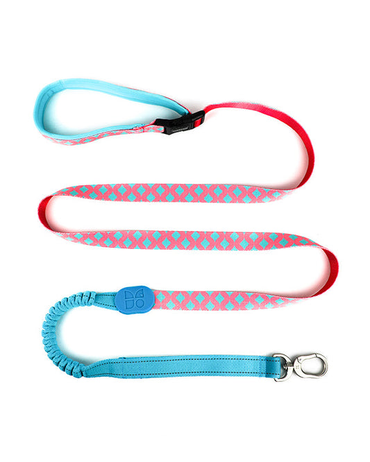 Colorful pink and teal patterned dog leash with padded handle, bungee shock absorber, and metal clip
