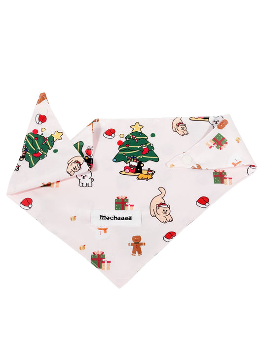 A light pink dog bandana featuring a festive Christmas print with cartoon cats, gingerbread men, Santa hats, and a Christmas tree. The bandana is displayed flat against a solid white background, with a white label in the center reading 'Mochaaaā'.