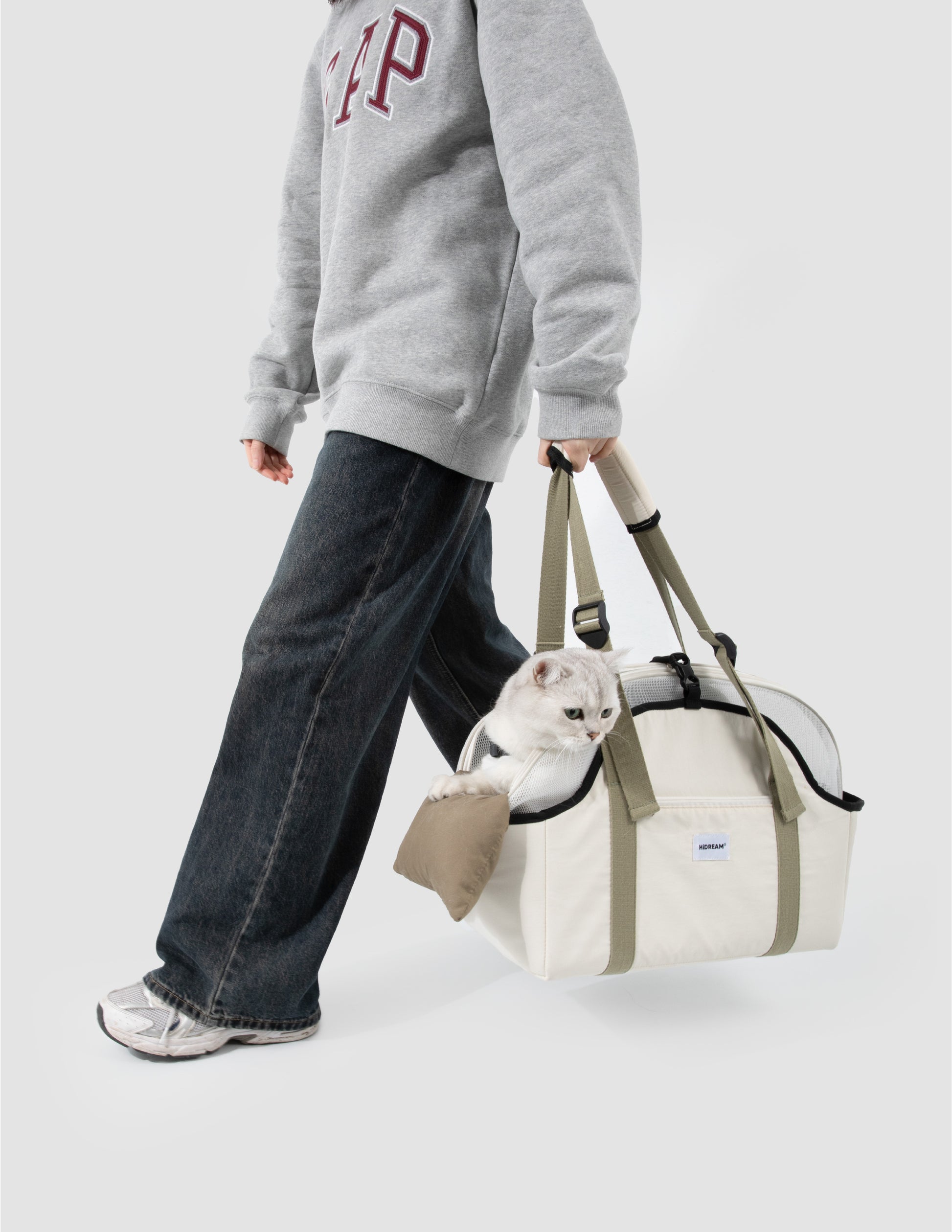 Woman holding a pet carrier bag with a small cat inside