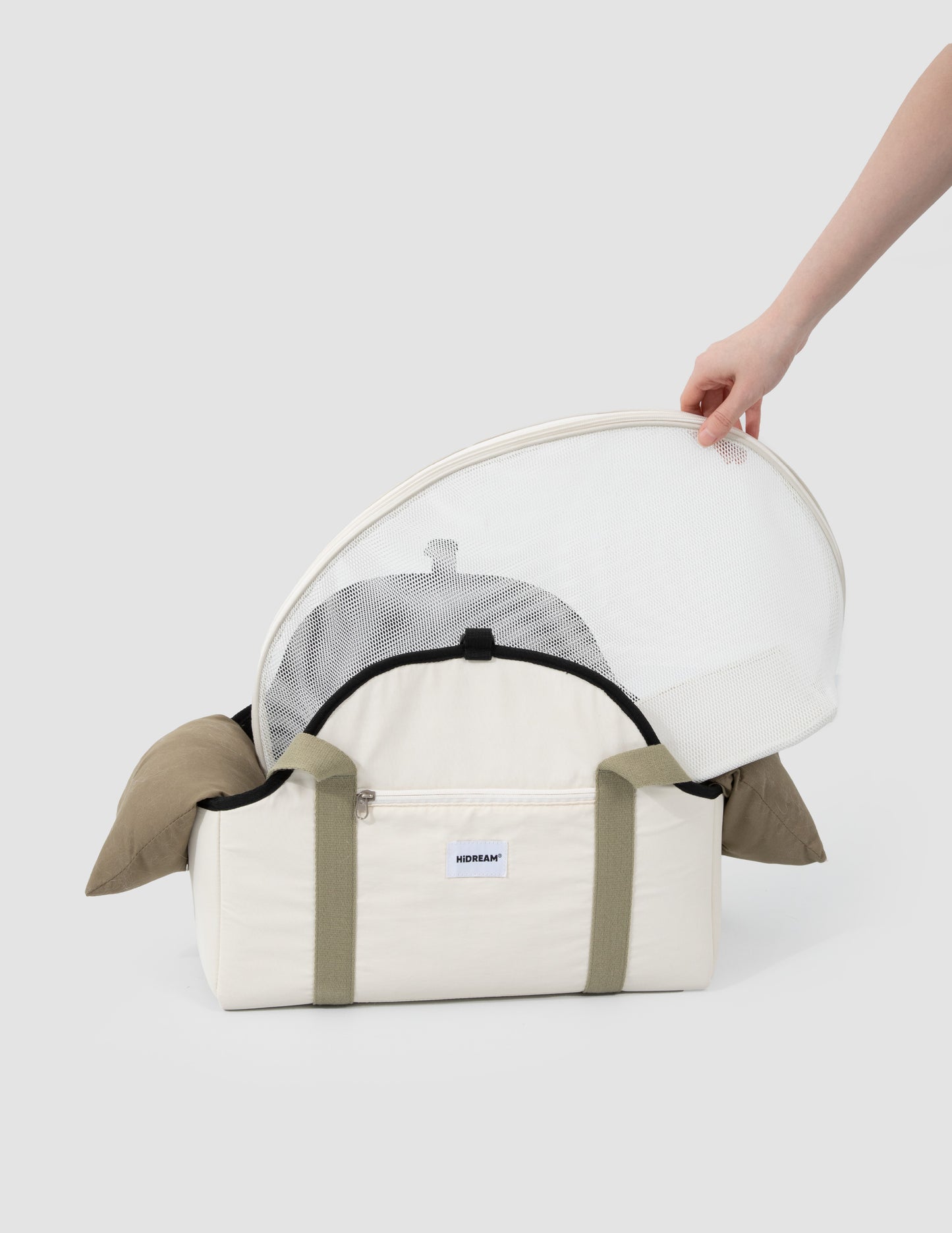 White pet carrier with transparent dome held by a hand on a white background