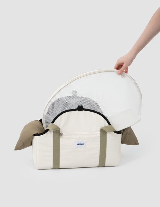 White pet carrier with transparent dome held by a hand on a white background