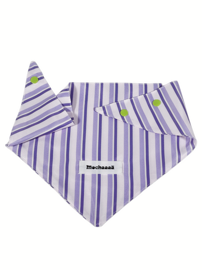 A striped pet bandana with vertical purple and white stripes, featuring two lime green snap buttons and a white brand label reading 'Mochaaaā'.