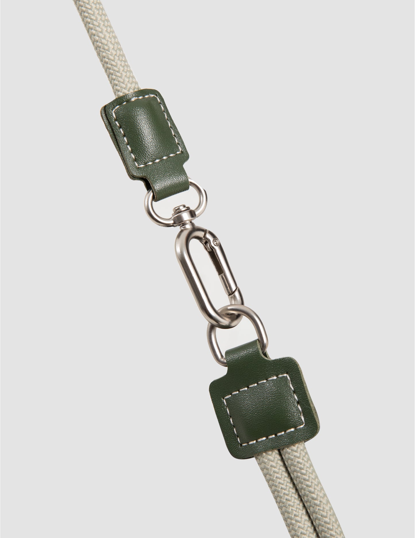 Green leather strap with metal clasp on a light gray background