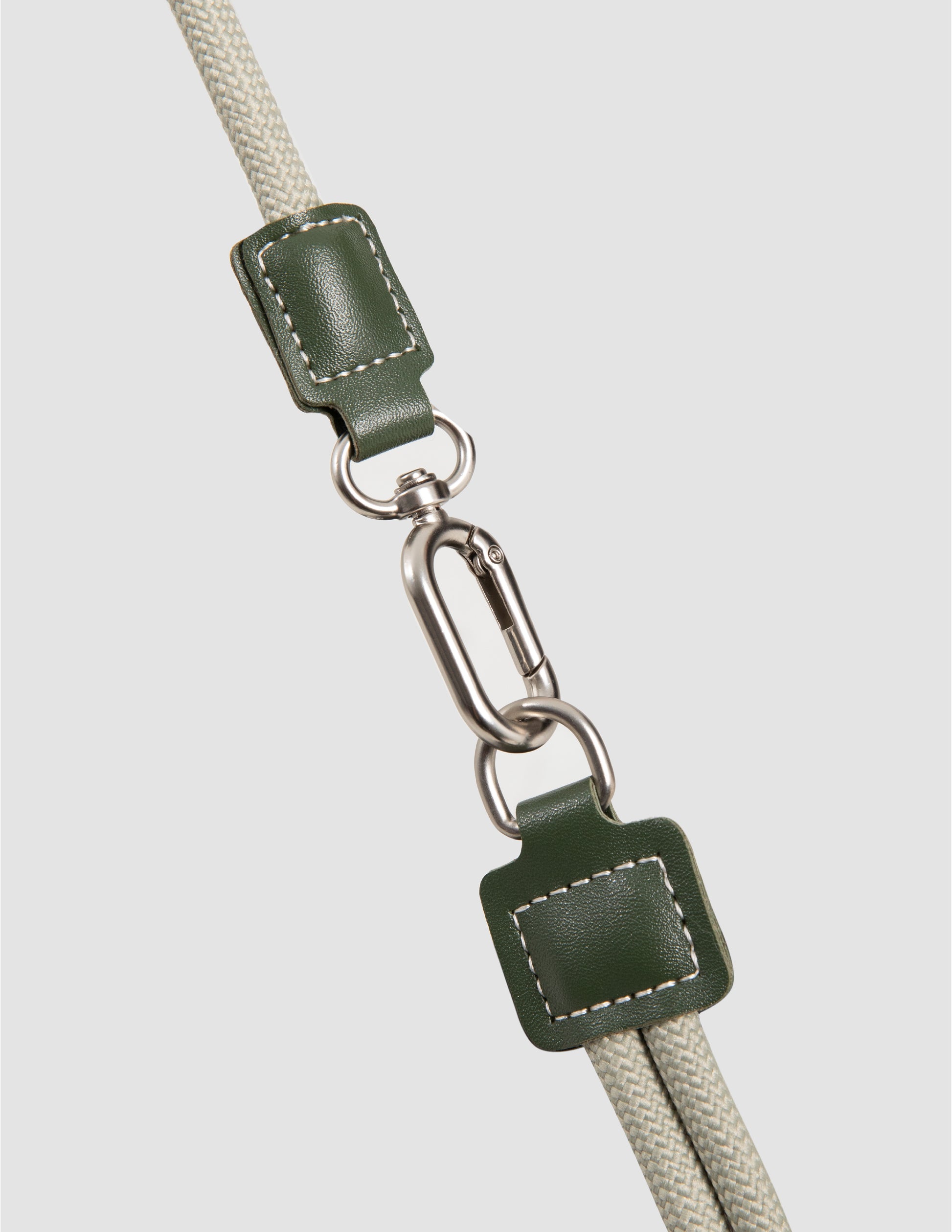 Green leather strap with metal clasp on a light gray background