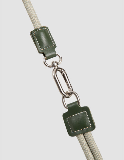 Green leather strap with metal clasp on a light gray background